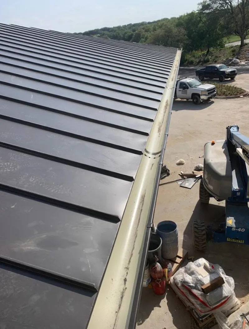 Standing seam panel and gutter detail on a metal roofing jobsite in Bucksport